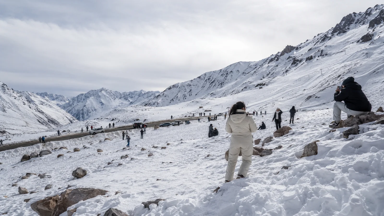 Visitantes caminando en un paisaje de alta montaña nevado